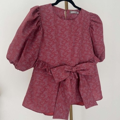 Vestido infantil vermelho com padrão floral e laço frontal