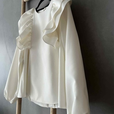 Blusa branca com babados e mangas bufantes pendurada