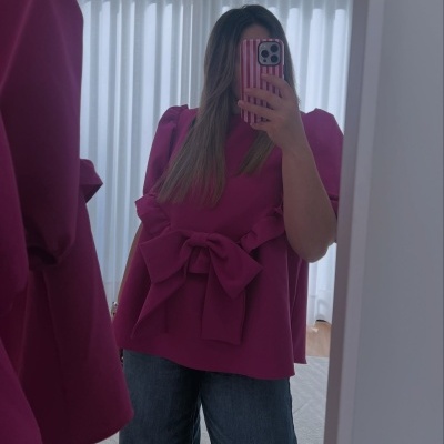 Blusa vinho com laço grande na frente e mangas bufantes, tirada em selfie no espelho.