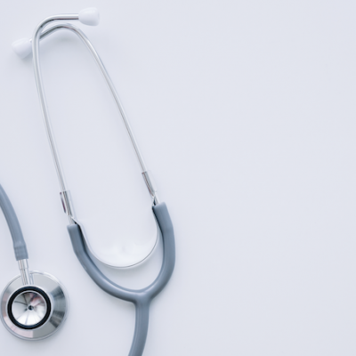 Estetoscópio cinza e branco sobre superfície branca