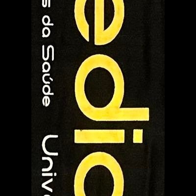 Toalha ou cachecol preto com franjas, texto e logótipo da Universidade do Minho