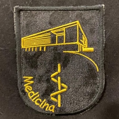 Emblema bordado com edifício amarelo e símbolo do caduceu, usado em vestuário.