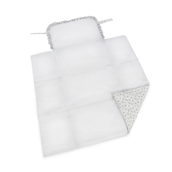 Manta acolchoada branca e almofada com folhos e padrão floral cinzento.