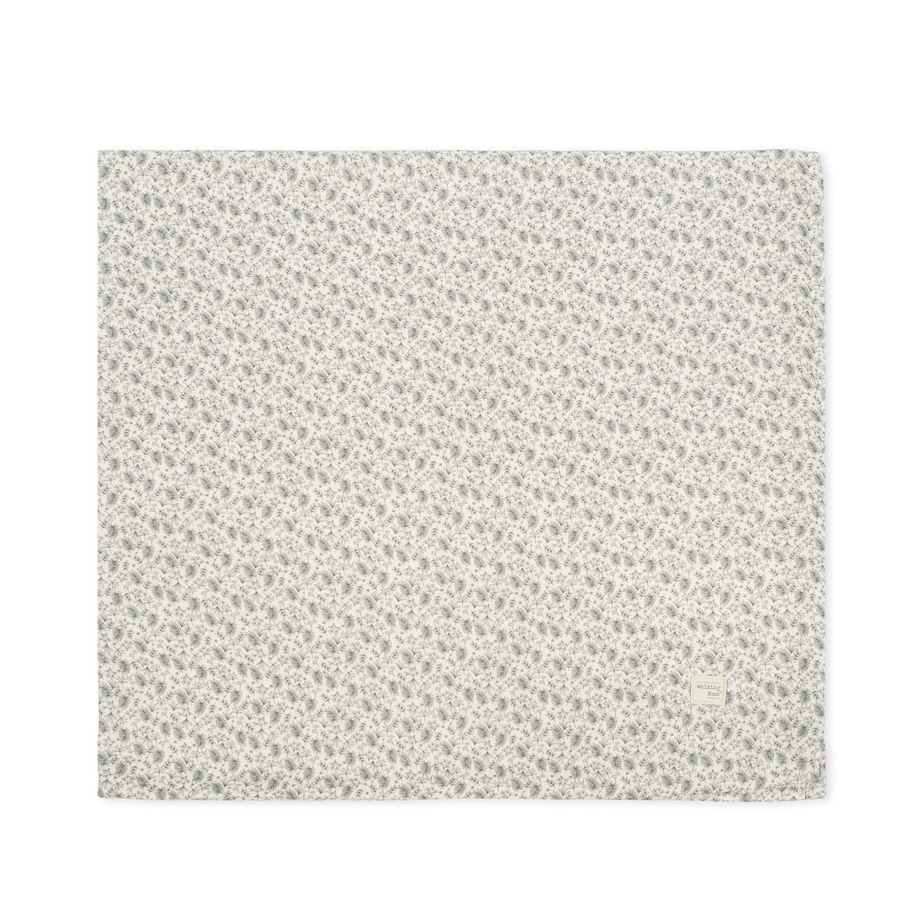 Manta branca com padrão de folhas verdes e etiqueta texturizada