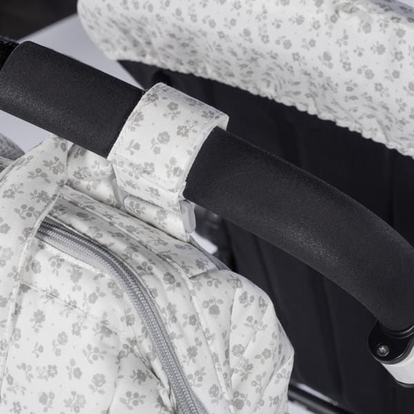 Carrinho de bebé com padrão floral cinza e branco e bolsa de armazenamento com fecho