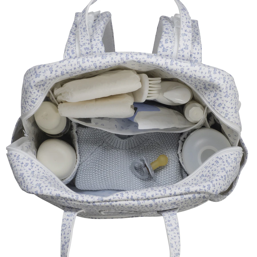 Saco de bebé branco com padrão floral azul aberto mostrando o interior organizado