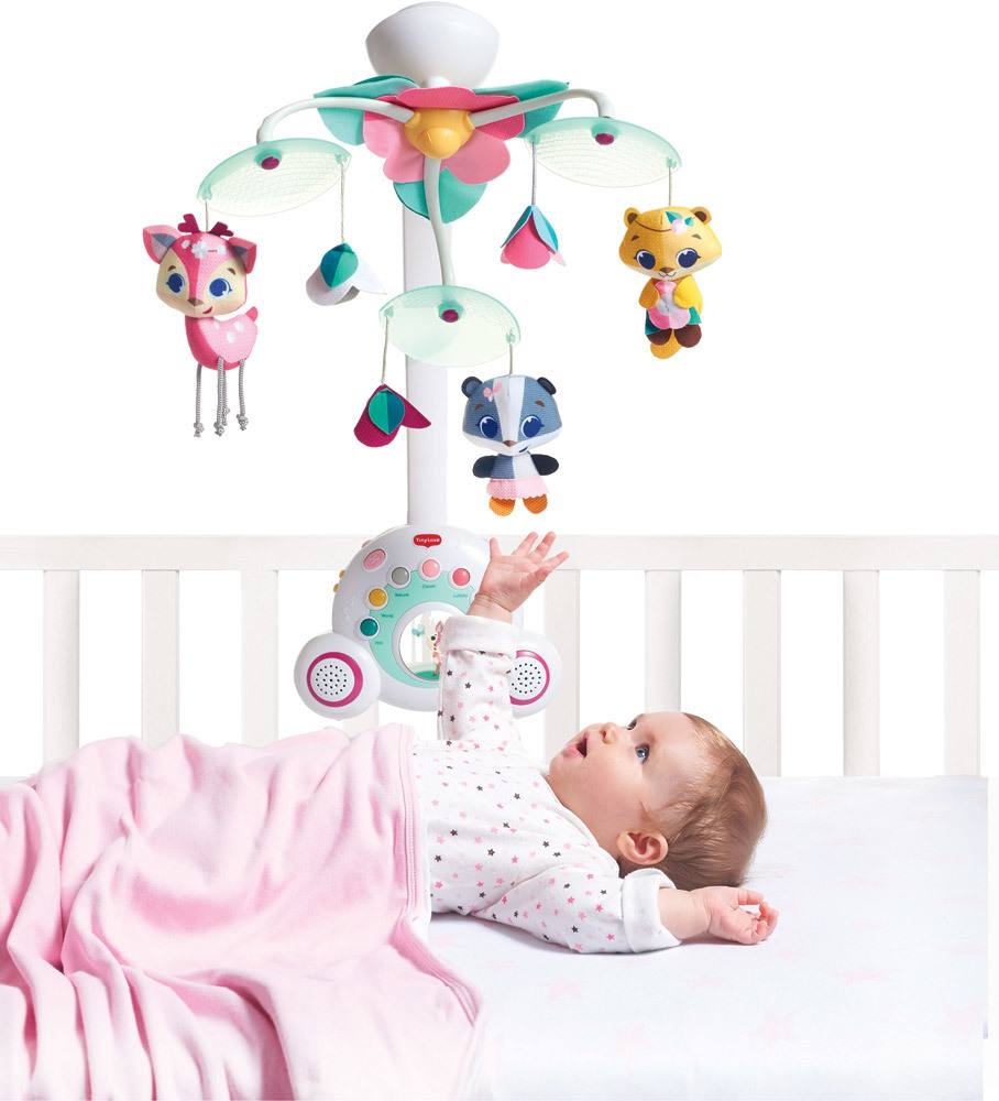 Bebé no berço olhando para móbil musical colorido com bonecos de animais
