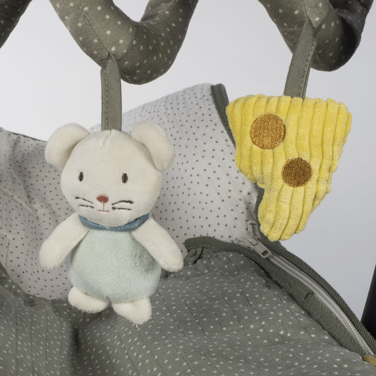 Brinquedos pendurados cinza com urso de pelúcia e fatia de queijo amarela