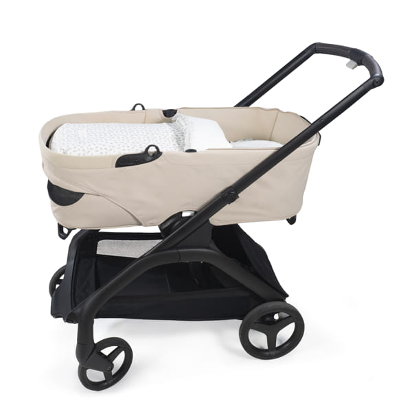 Carrinho de bebé bege com estrutura preta e assento acolchoado