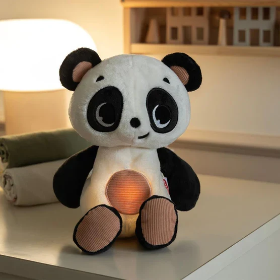 Pelúcia panda com luz no centro sentada sobre superfície branca