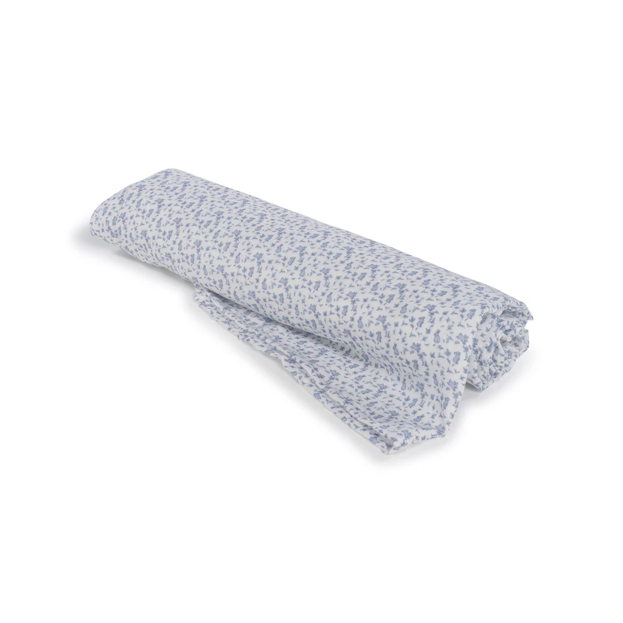 Tecido de algodão branco com padrão floral azul enrolado