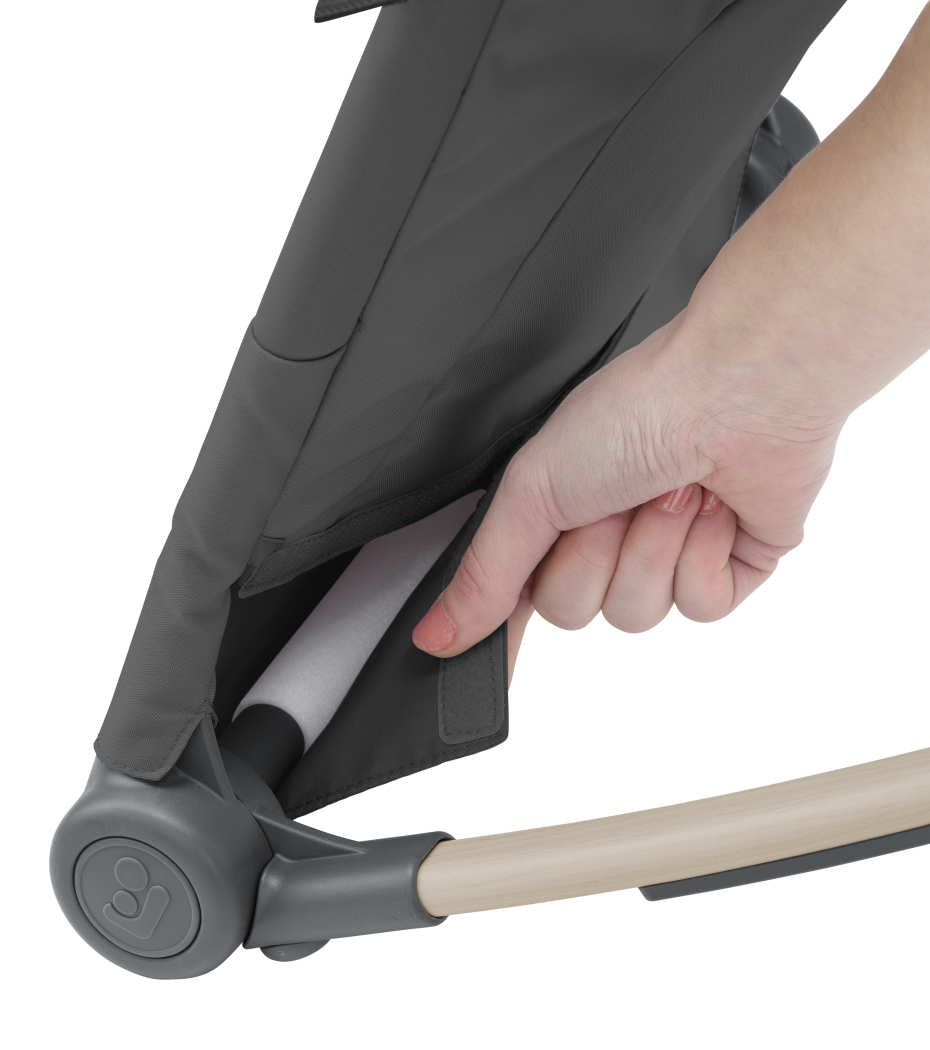 Mão a puxar aba em tecido cinzento de cadeira com estrutura de madeira e plástico