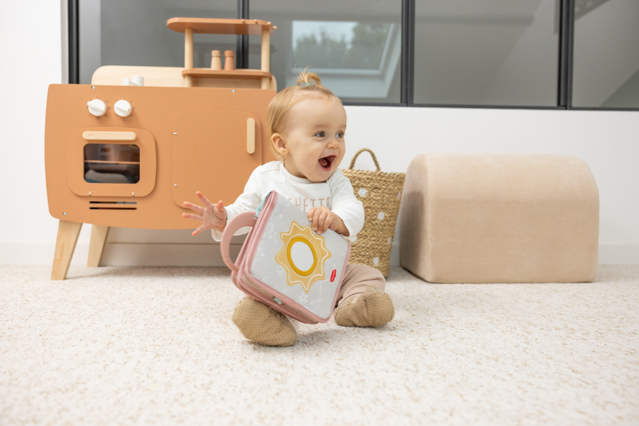 Bebé com livro de pano e móveis de brincar