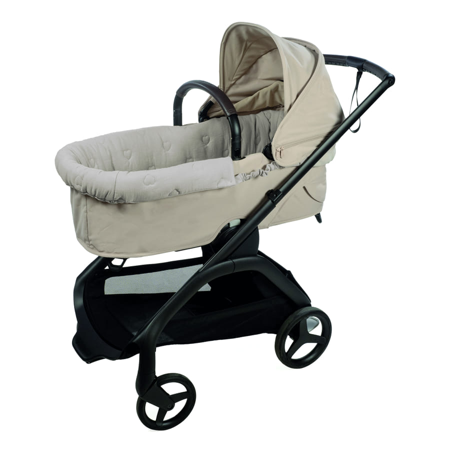 Carrinho de bebé bege com estrutura preta e rodas