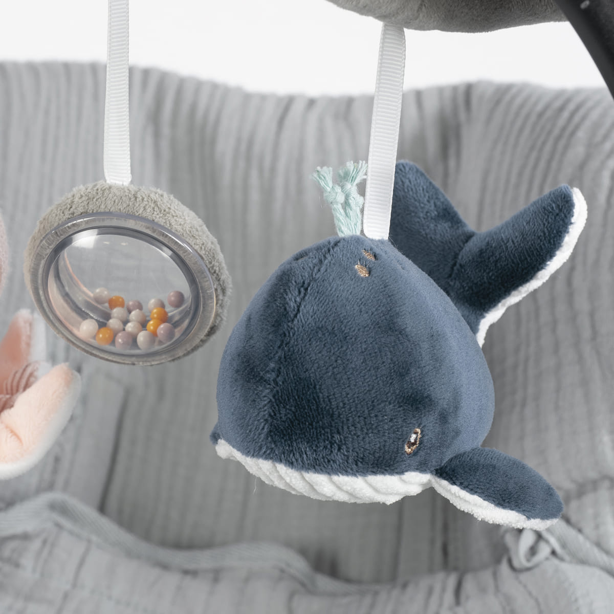 Brinquedo de peluche baleia azul e brinquedo com bolas coloridas pendurados