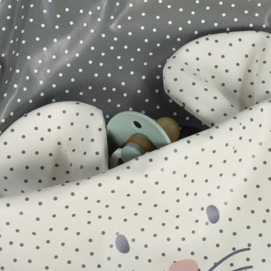 Almofada infantil branca com bolinhas e feições de rosto, chupeta verde