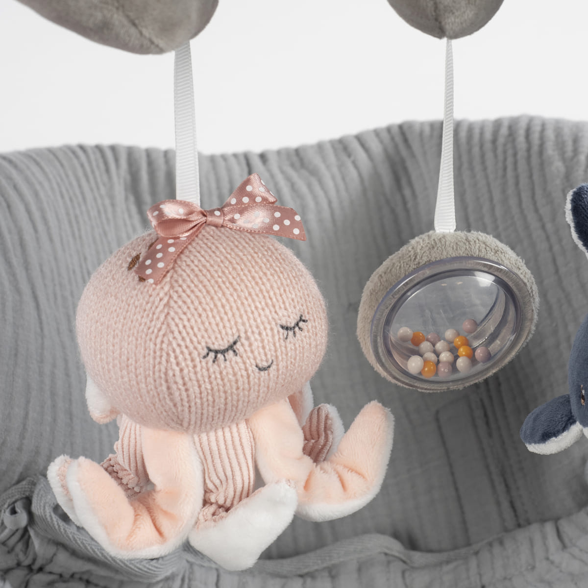 Pelúcia de polvo cor-de-rosa com laço rosa suspensa por fita branca