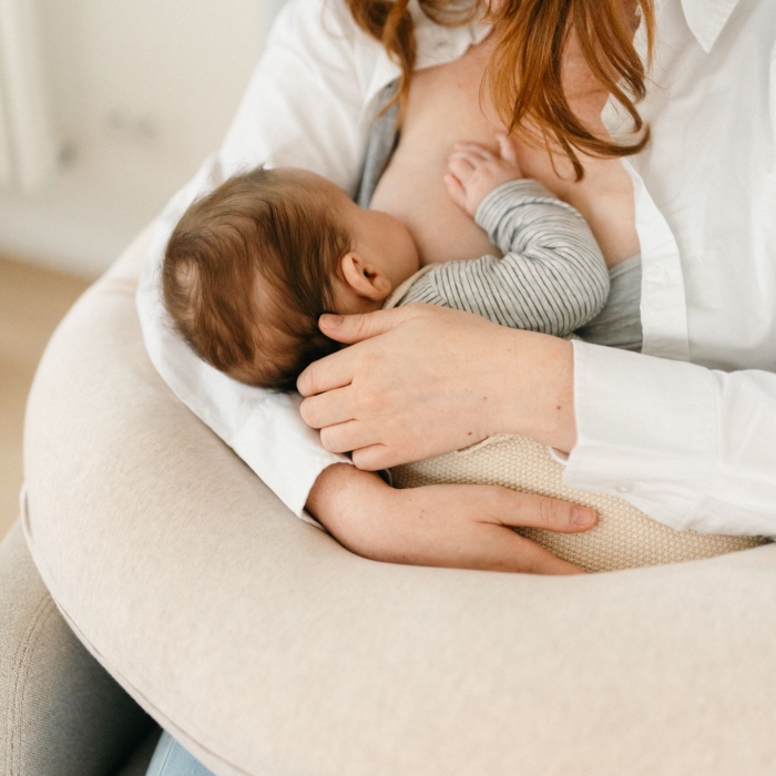 Almofada de amamentação bege com bebé a mamar