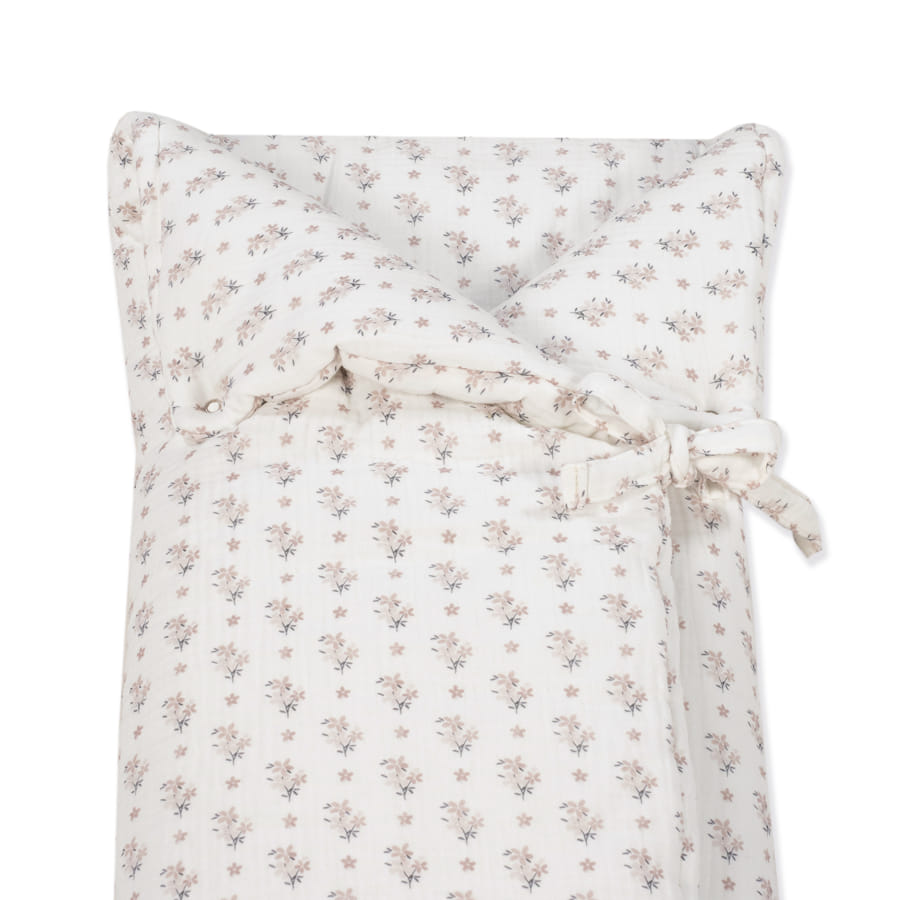 Edredão branco com padrão floral e laço de fecho