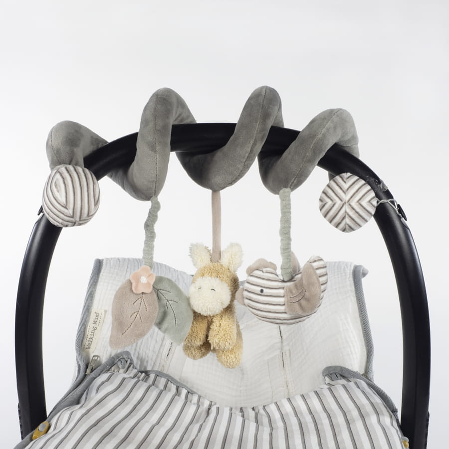 Arco de carrinho com brinquedos pendurados de tecido cinza e bege sobre tecido listrado.