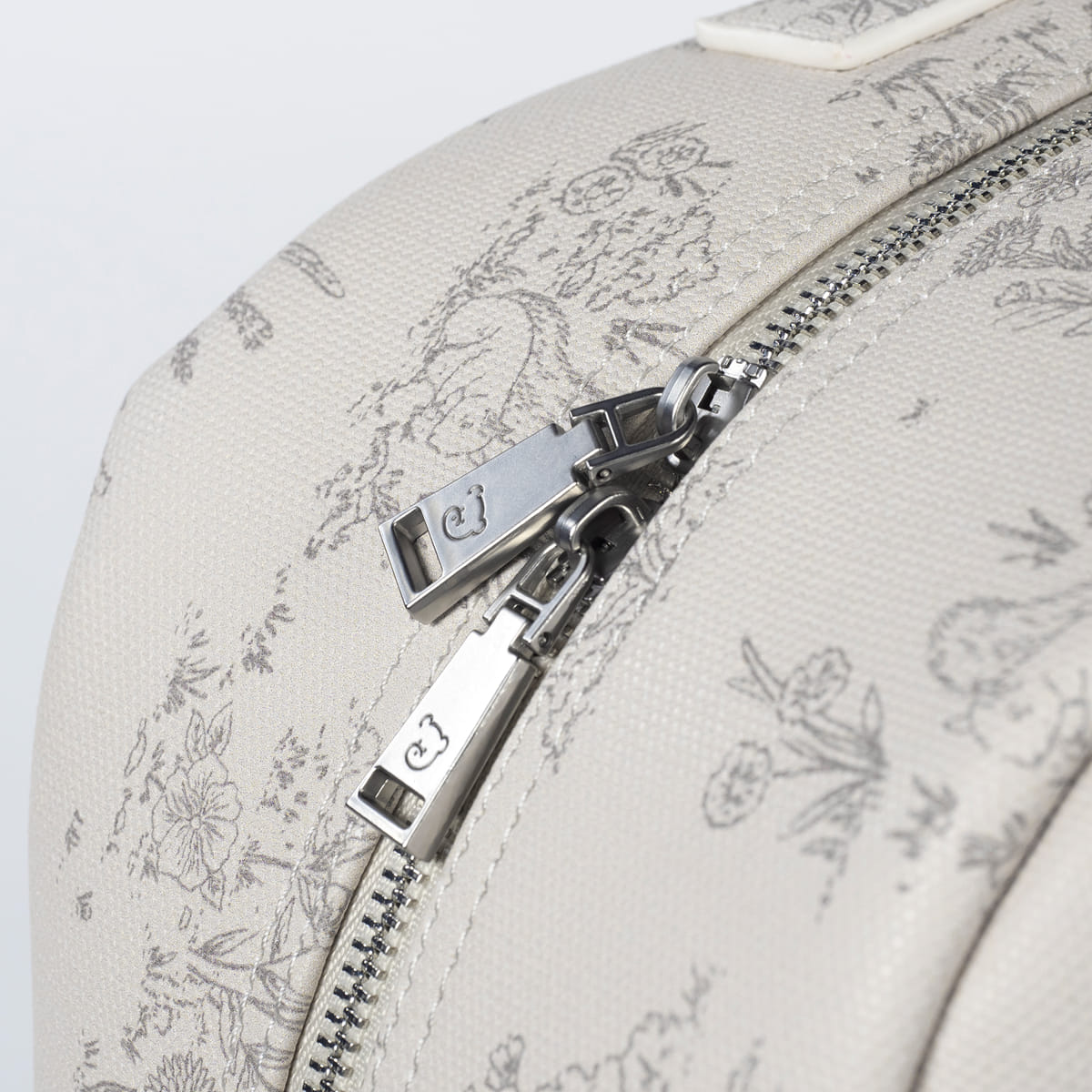 Saco branco com padrão floral e fecho de correr metálico com puxadores 'cj'