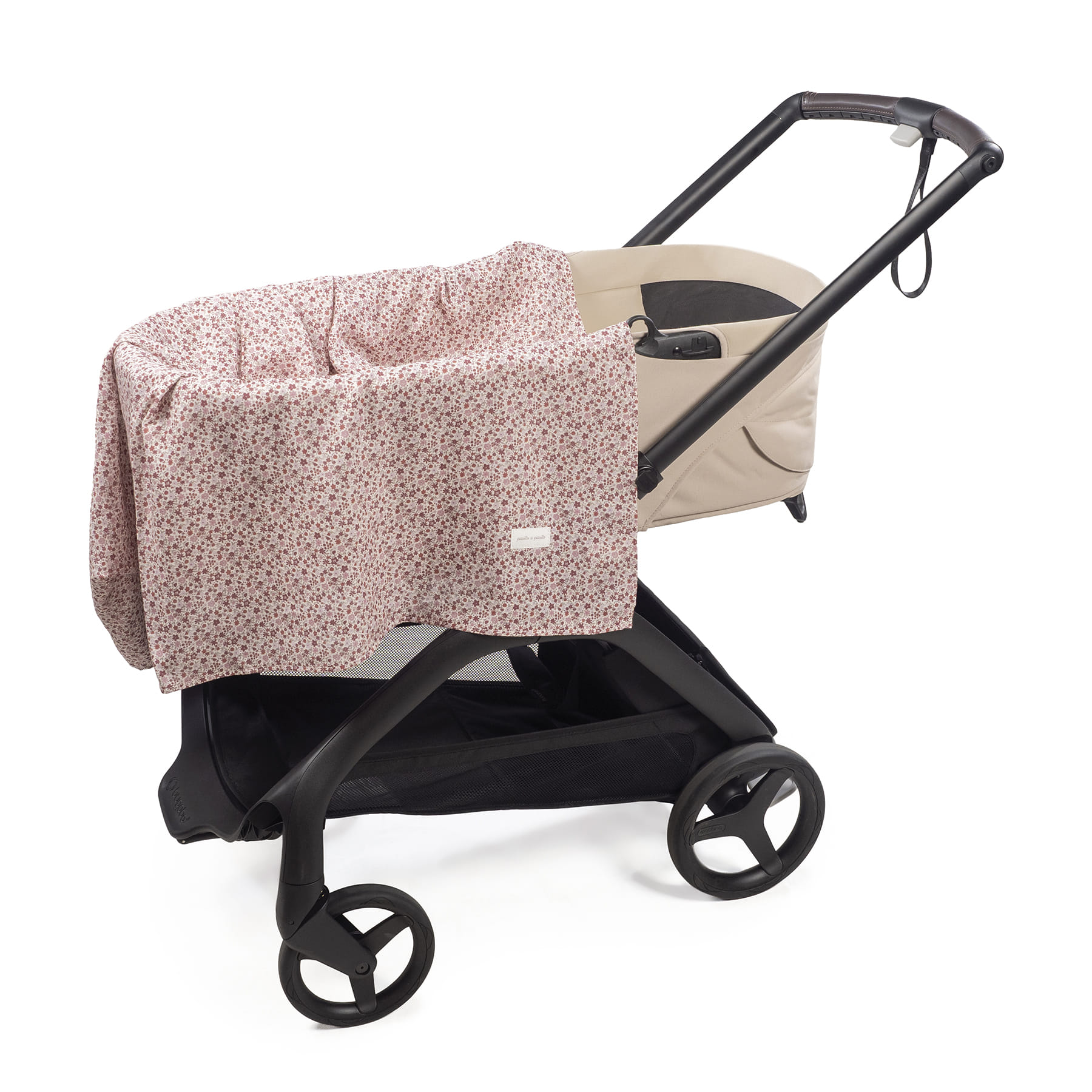 Carrinho de bebé bege com estrutura preta e coberto por tecido floral rosa.