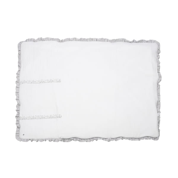 Colchão ou almofada branca retangular com bordas cinzentas onduladas e fitas com bolinhas.