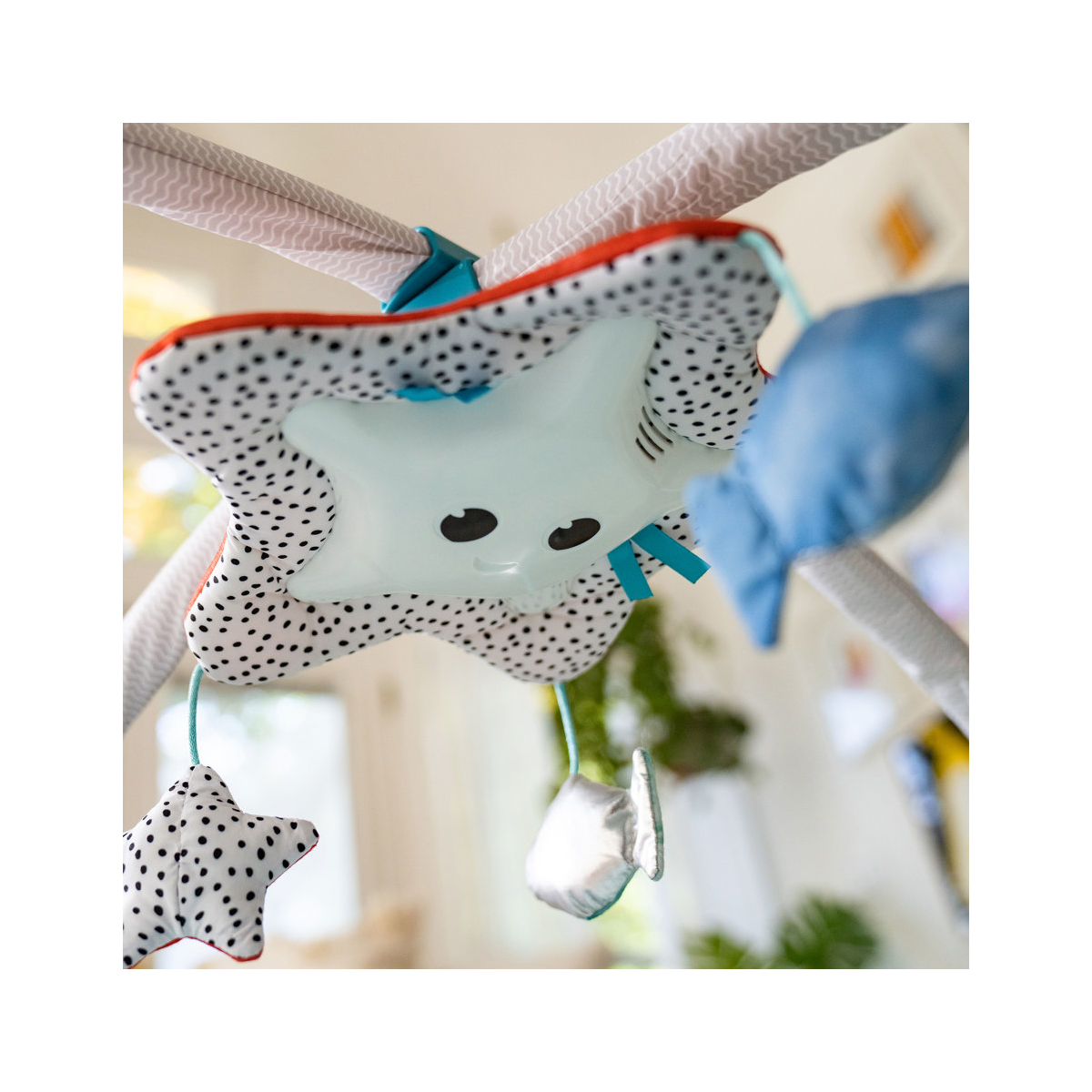 Móvel infantil de tecido em forma de estrela com pendurais no interior de casa