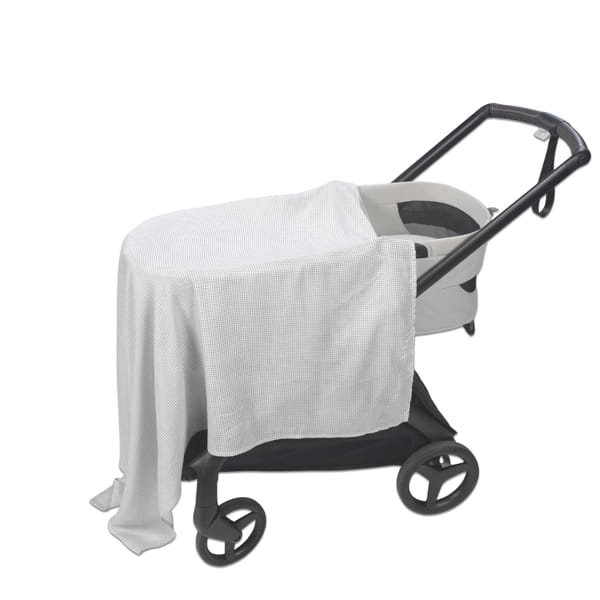 Carrinho de bebé cinza com cobertura branca de tecido leve