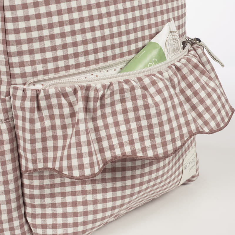 Mala xadrez bege e branco com bolso frontal e pacote verde dentro