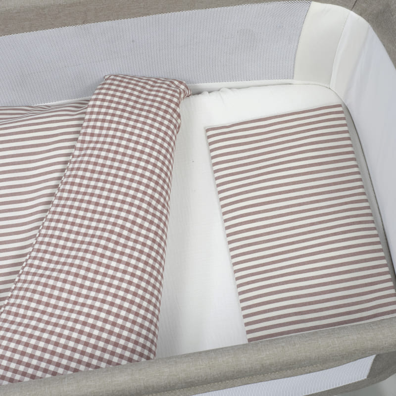 Berço de bebé com almofada e cobertor bege e branco