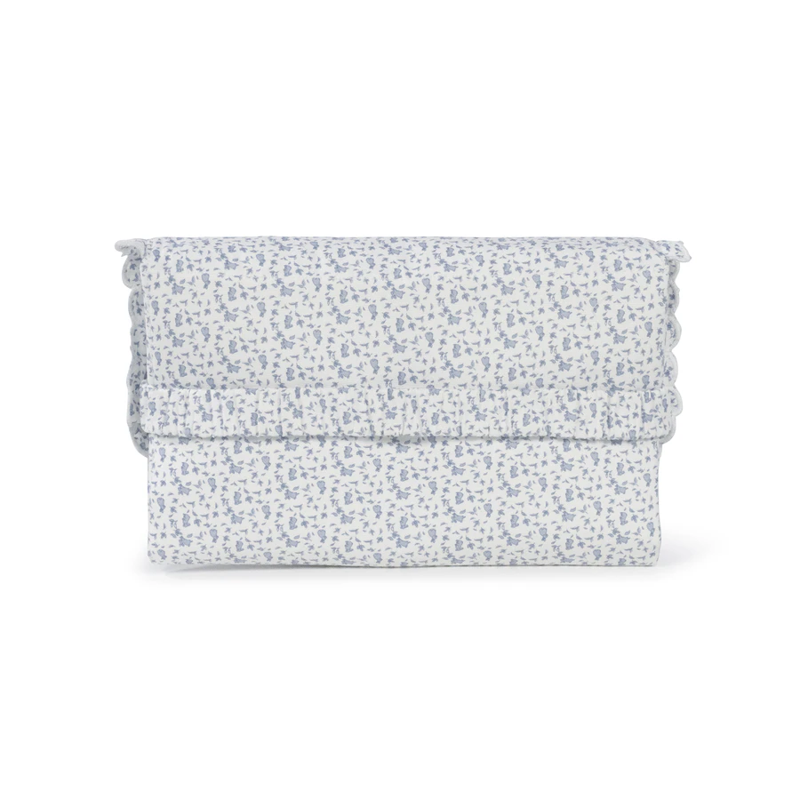 Mala de mão em tecido branco com padrão floral azul claro e acabamento ondulado nas bordas.
