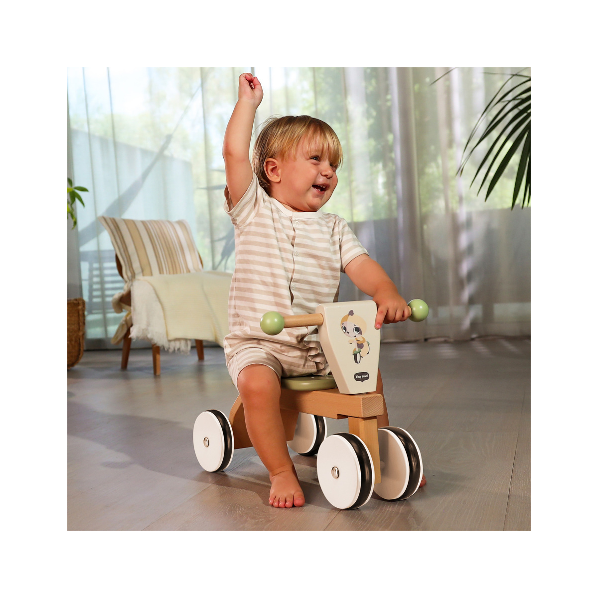 Criança a brincar num triciclo de madeira em interior iluminado