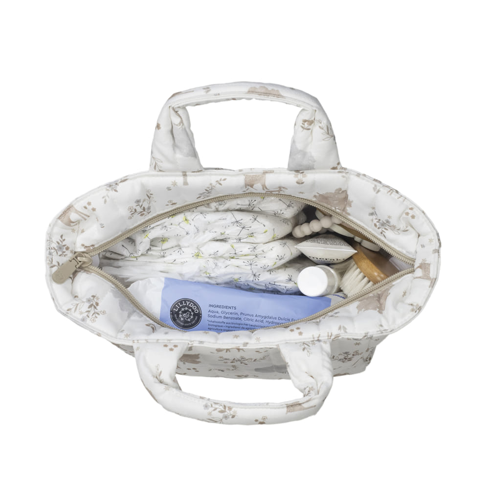 Bolsa de tecido branco floral com itens de higiene dentro