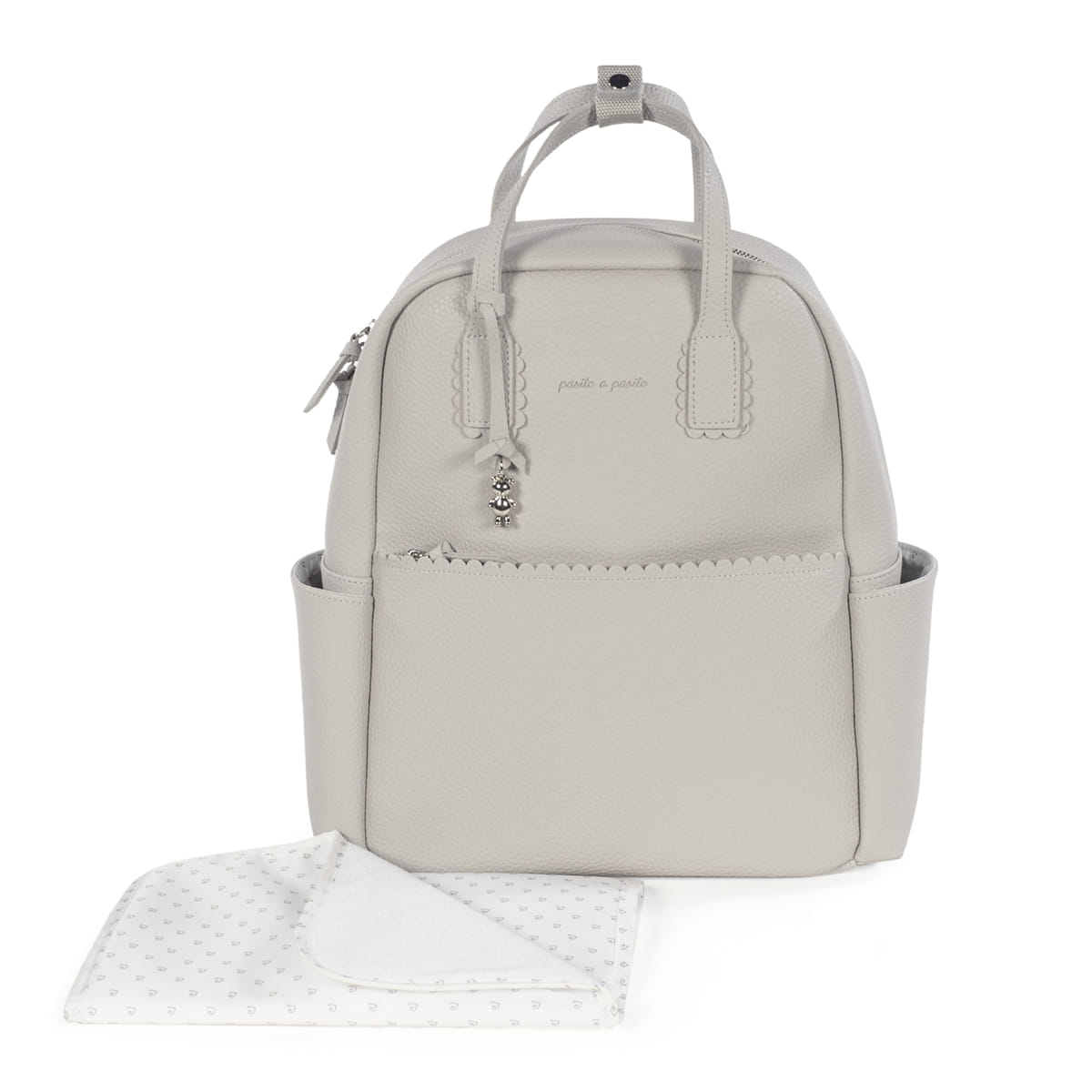 Mochila pequena cinzenta de pele com pendente prateado e pano branco com padrão de pontos