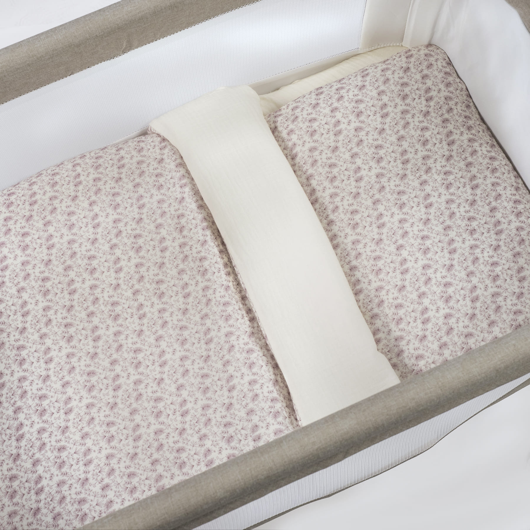 Berço com colchão e almofada floral e faixa acolchoada branca