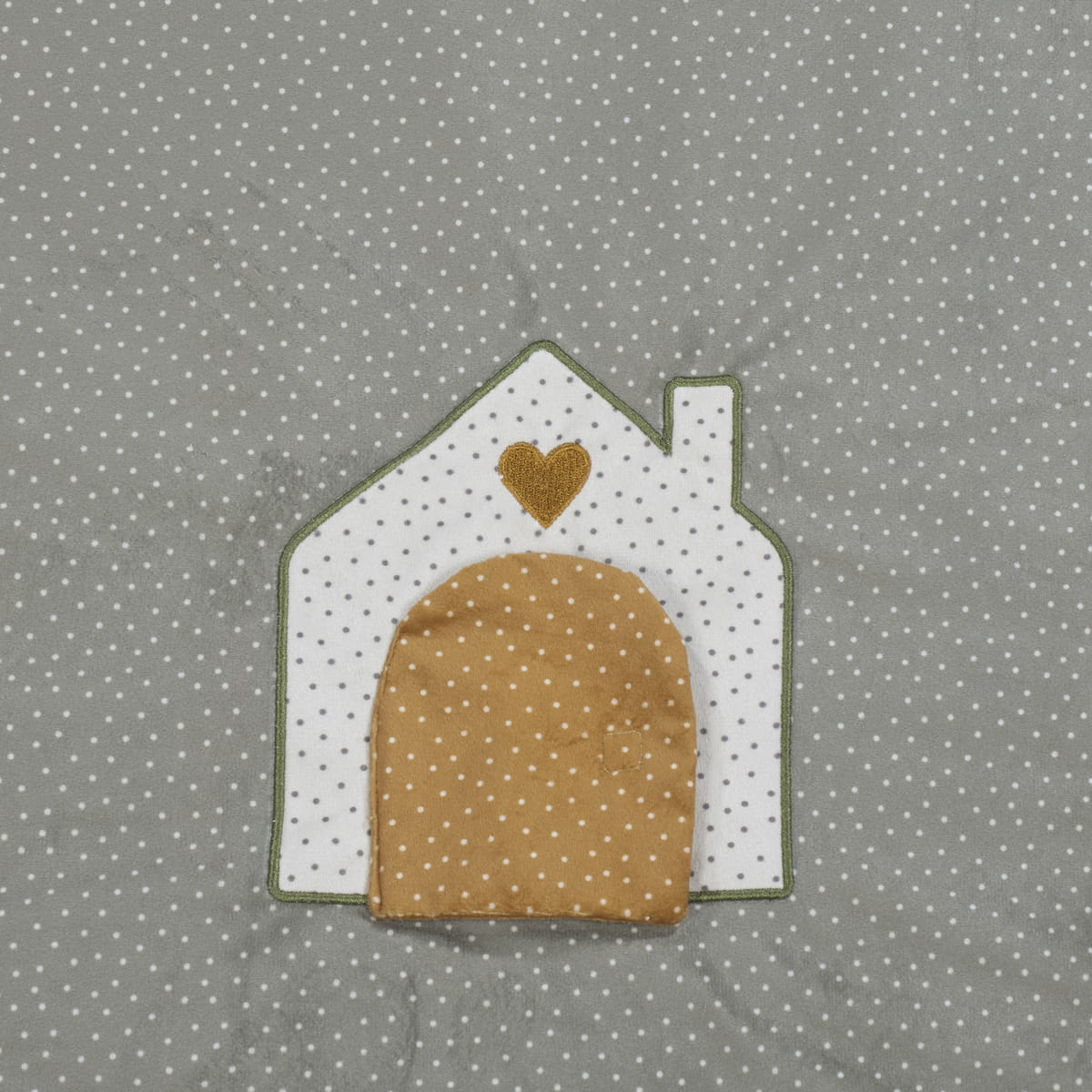 Tecido cinzento com padrão de estrelas e aplicação em forma de casa com porta e coração