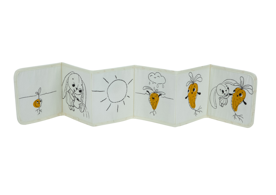 Livro de tecido infantil com desenhos de cenouras, sol, nuvem e cão