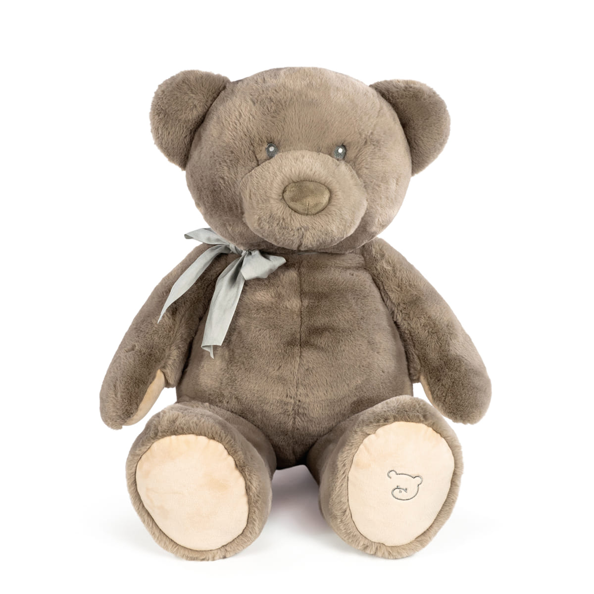 Urso de peluche castanho com laço cinzento sentado sobre fundo branco
