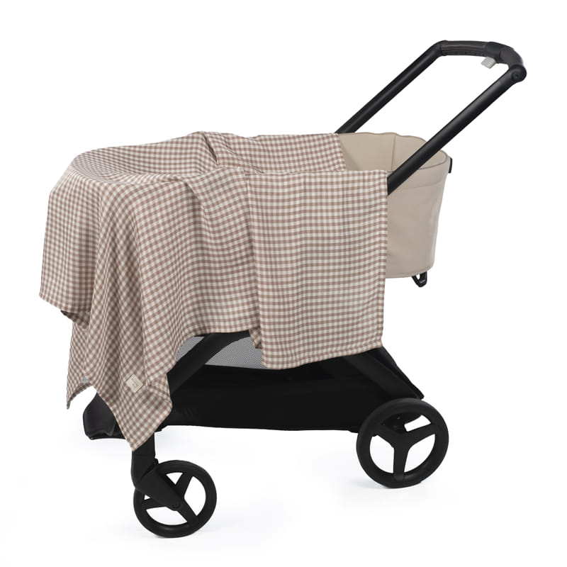 Carrinho de bebé bege com manta xadrez bege e branco