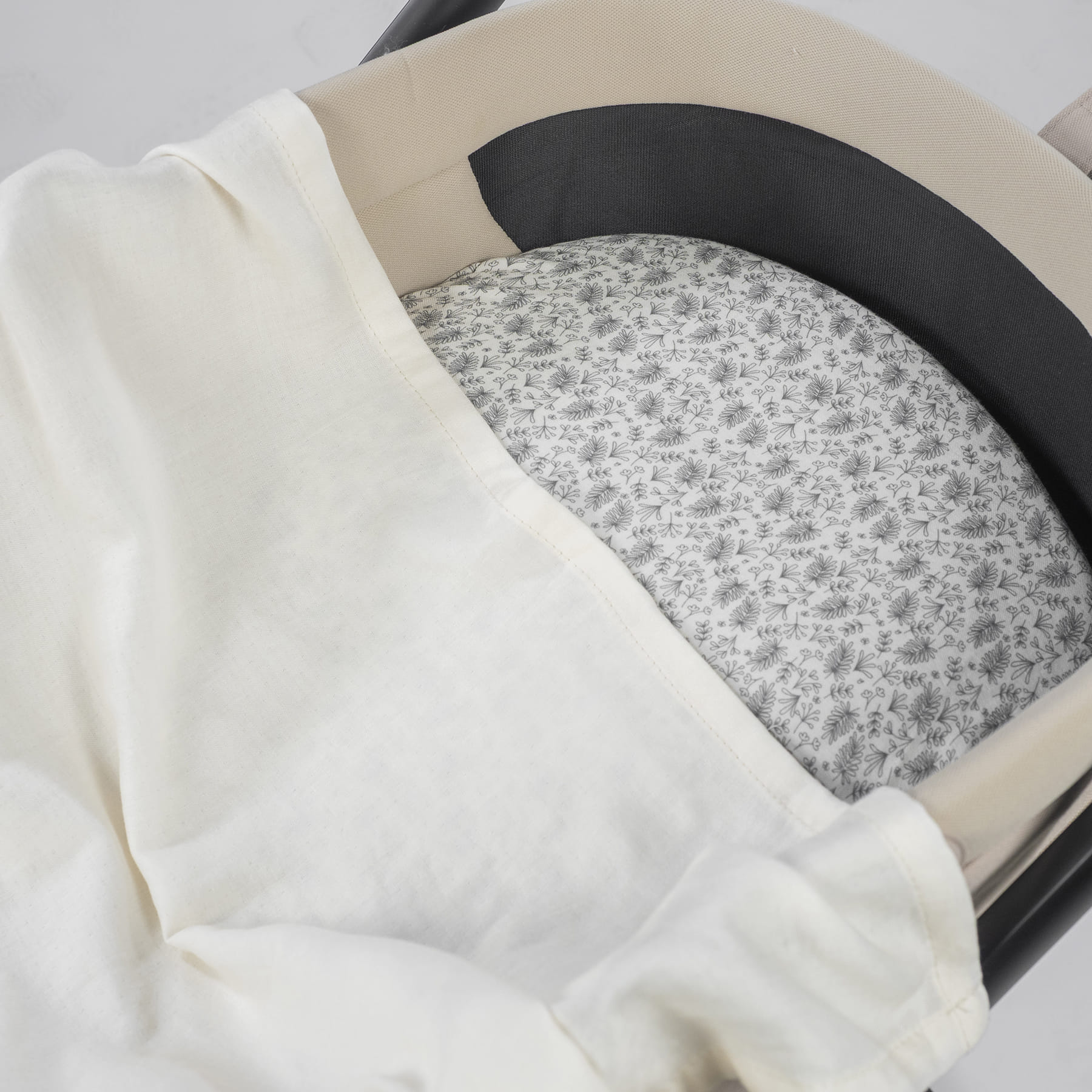 Cama de bebé com almofada estampada e tecido branco sobreposto