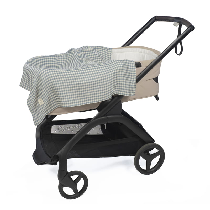 Carrinho de bebé bege com cobertura xadrez azul clara e branca sobre estrutura preta.