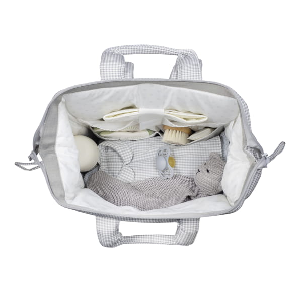 Bolsa de bebé aberta com peluche, escova, chupeta e outros itens