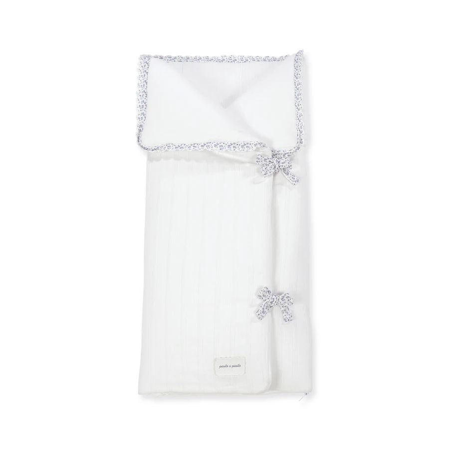 Saco para bebé branco com acabamento em padrão floral e laços decorativos.