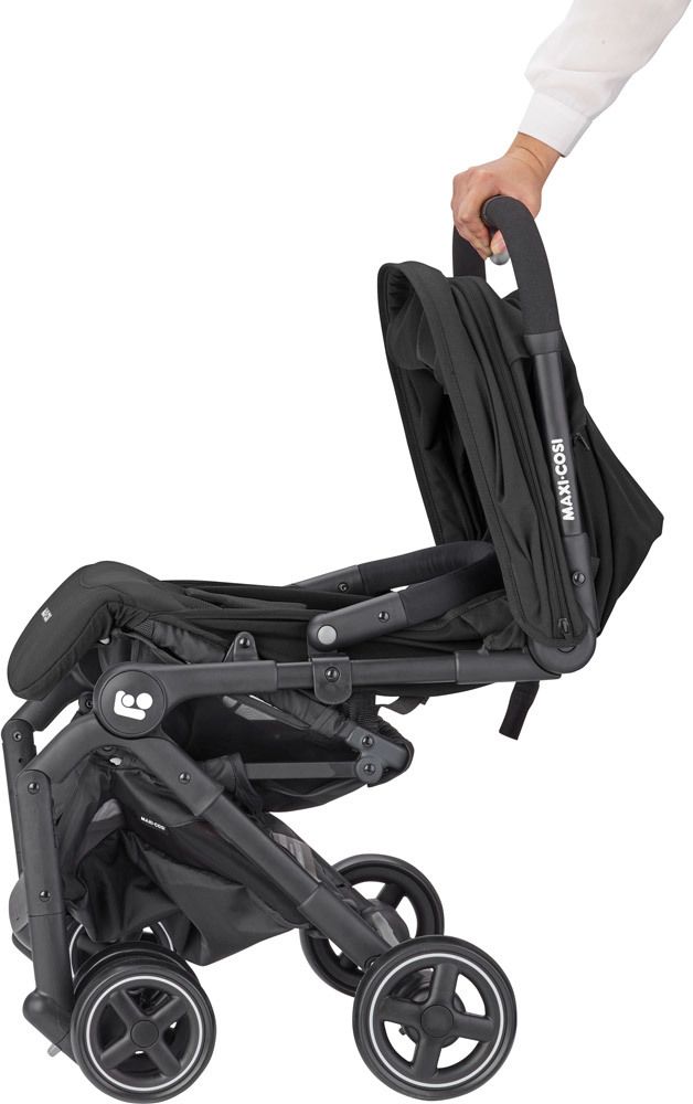 Carrinho de bebé Maxi-Cosi preto em posição reclinada com mão segurando o punho