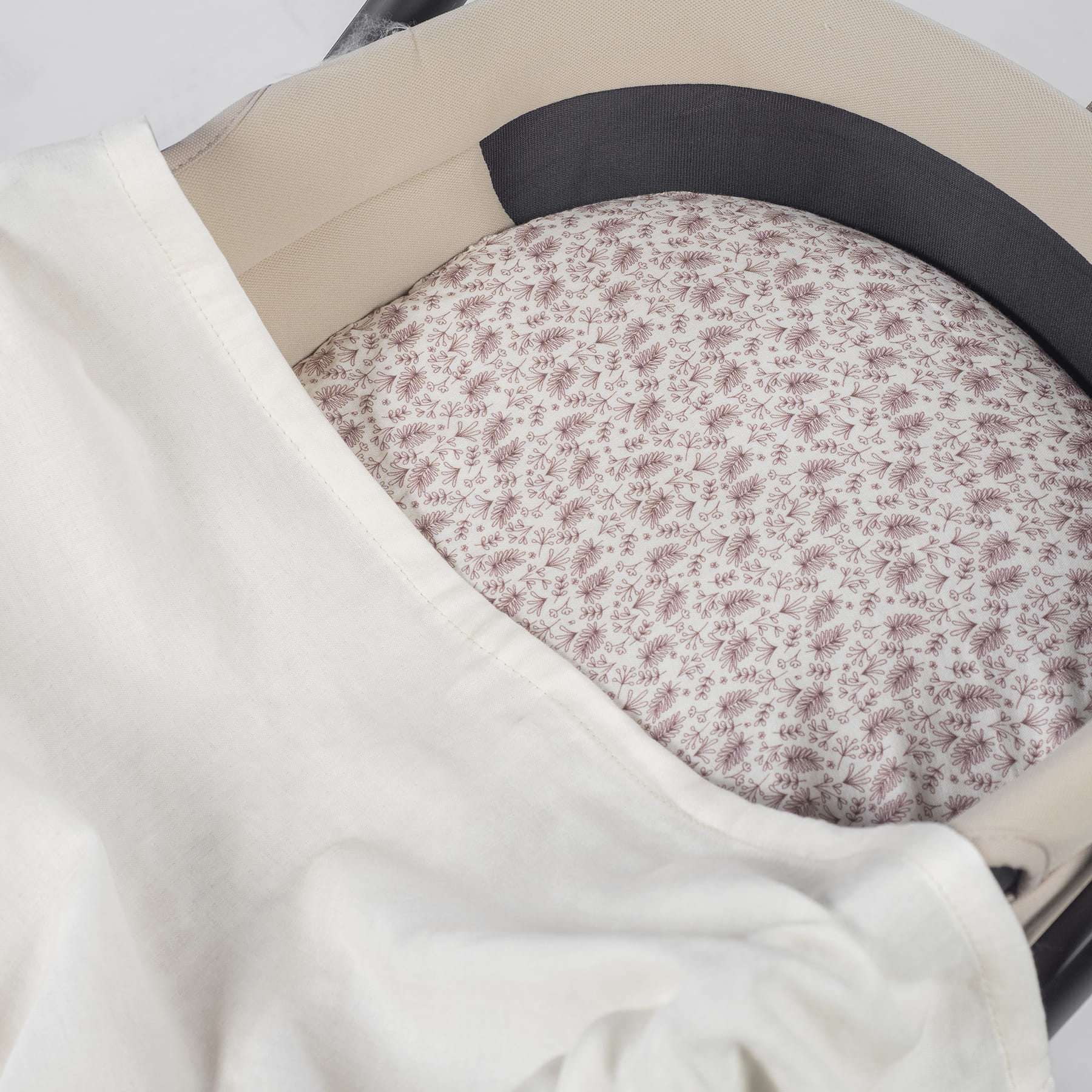 Interior de carrinho com almofada floral lilás e manta branca