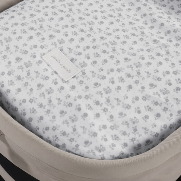 Colchão com padrão floral cinzento e etiqueta pacta pacta em cama com bordas bege