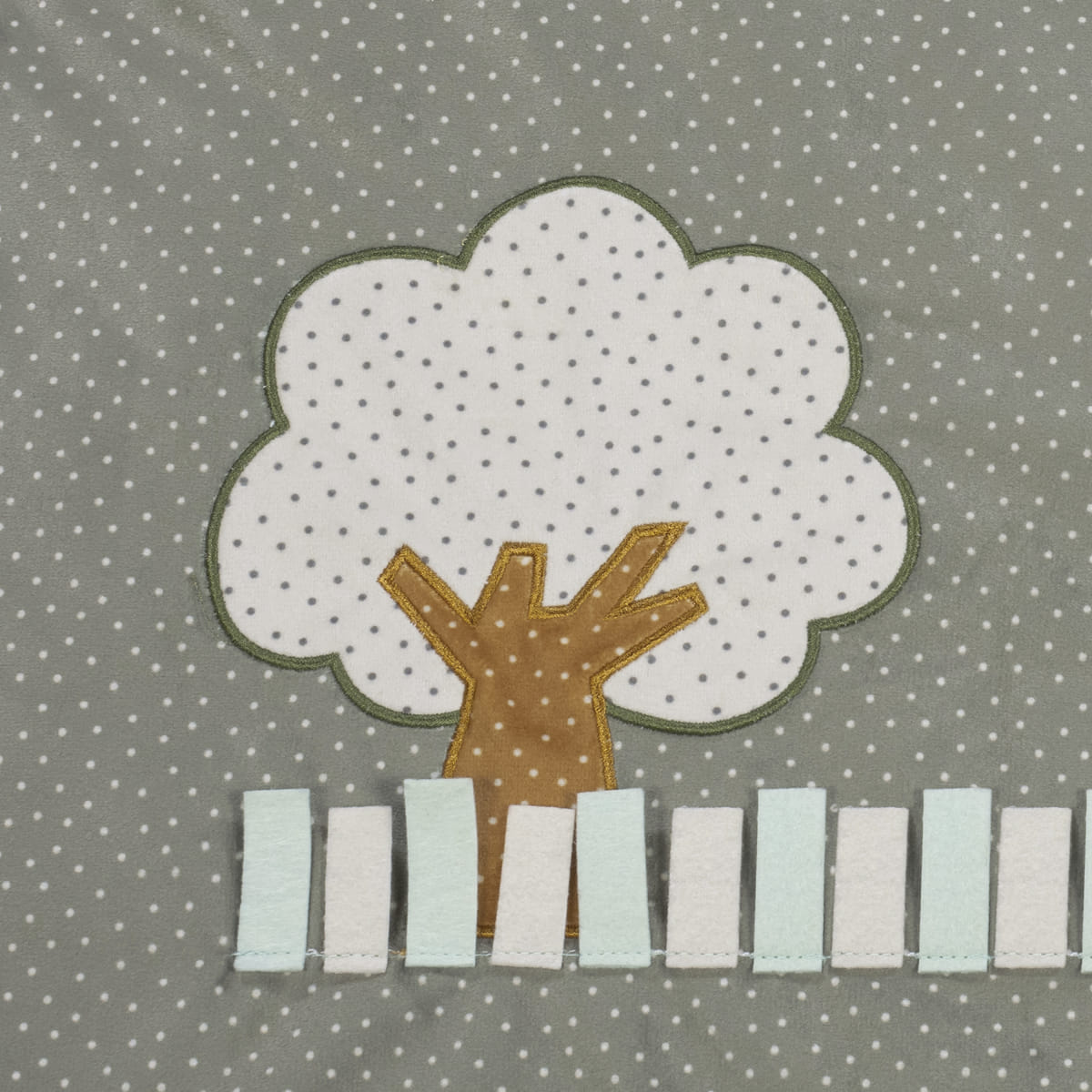 tecido cinza com aplicação de árvore e cerca em tecido com padrão de bolinhas