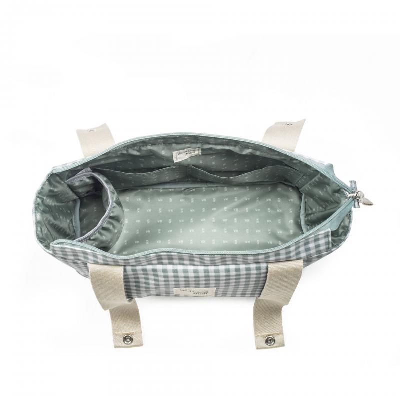 Mala xadrez cinza e branco aberta com interior verde claro e alças bege.