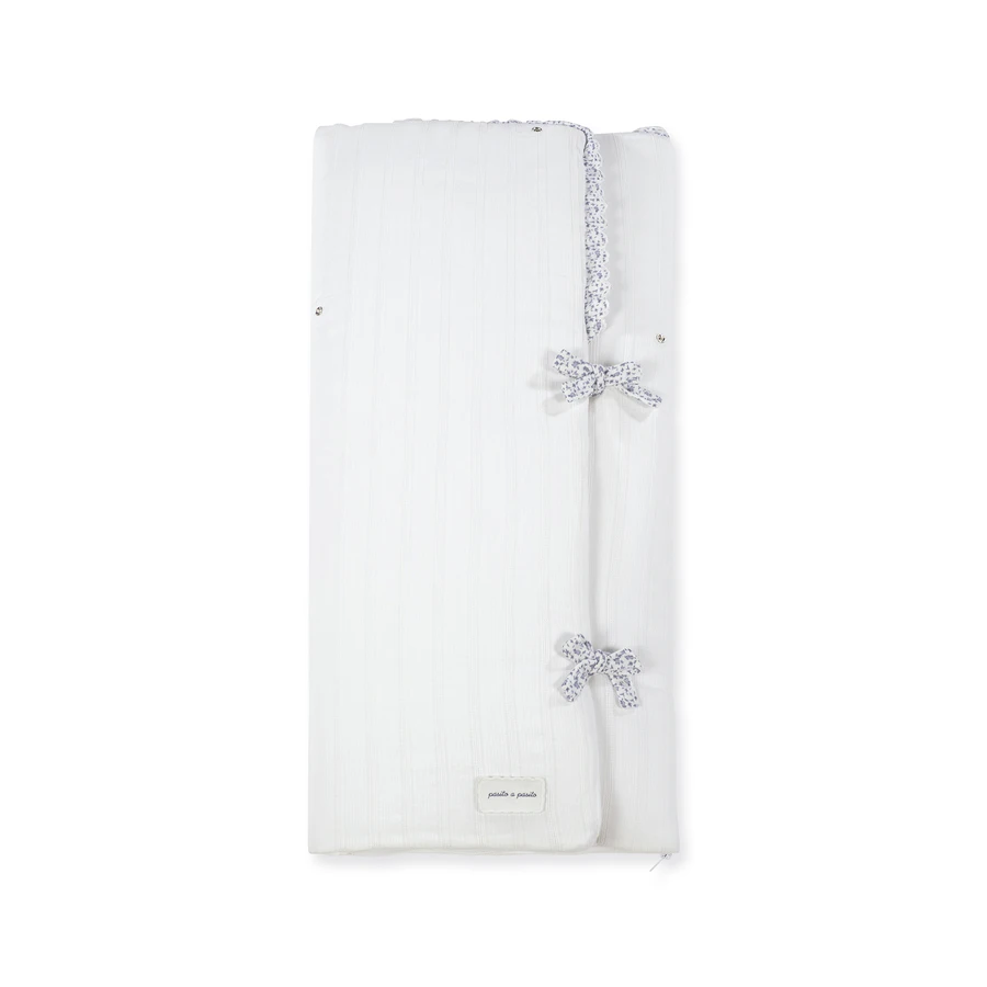 Cobertor branco com fitas e detalhe de renda